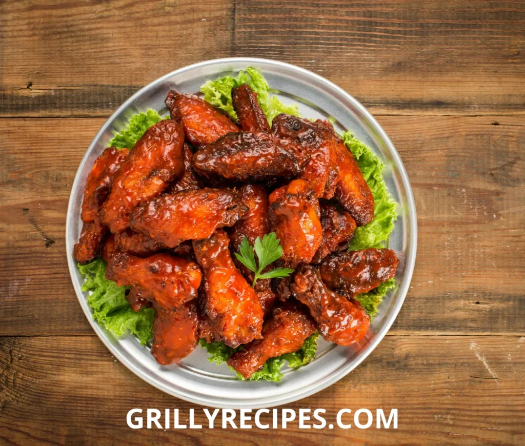 Grilled boneless chicken breasts with golden grill marks on a wooden platter.


