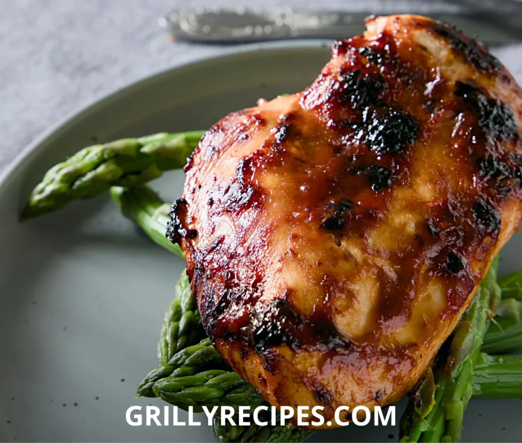Grilled chicken breasts marinated in a healthy chicken marinade with lemon, garlic, and fresh parsley on a wooden platter
