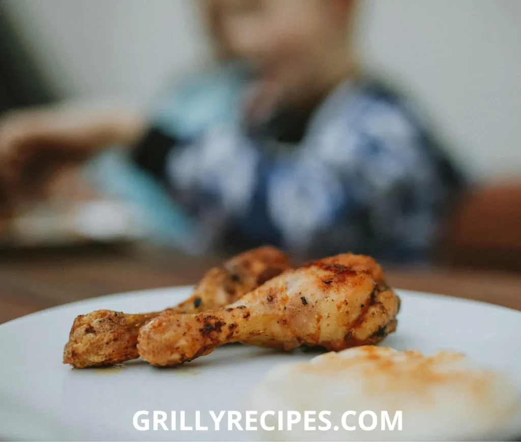 Crispy keto chicken thigh with golden skin on a plate with rosemary garnish
