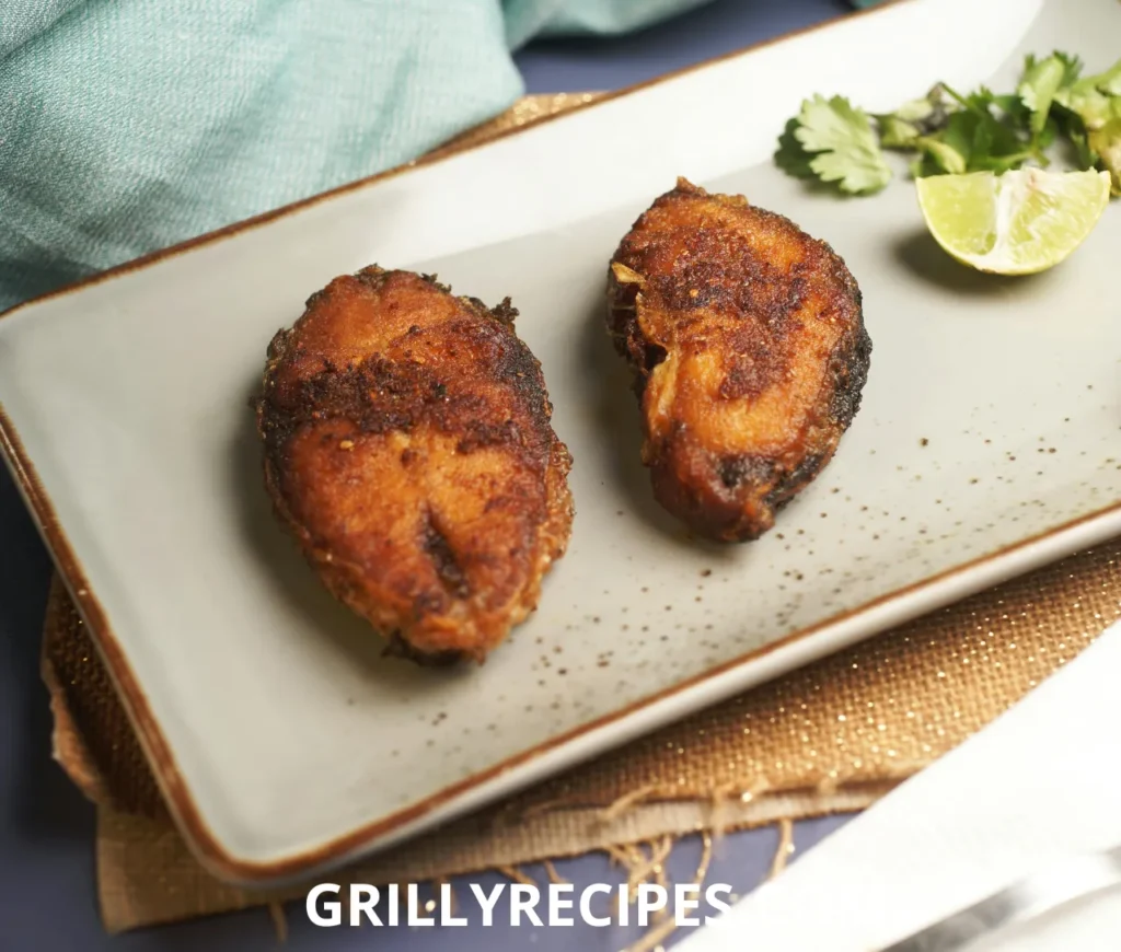 Golden fried cod fish fillets coated in cornmeal, seasoned with paprika and garlic, garnished with fresh parsley and a lemon wedge on a rustic plate, highlighting a crispy fried cod fish recipe.